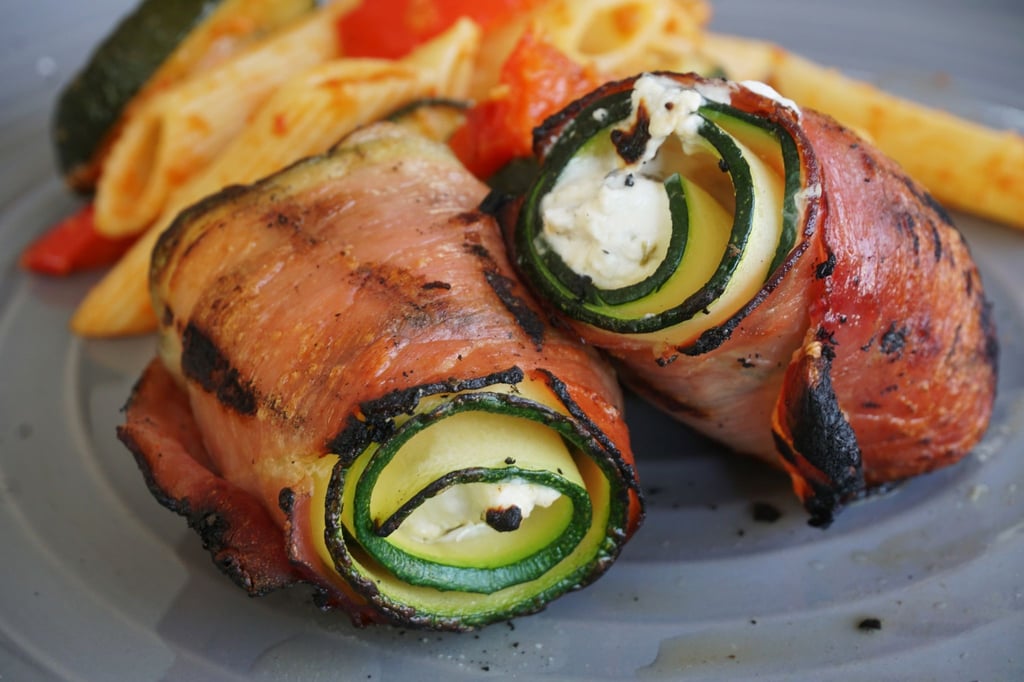 Klein, aber oho: Die Röllchen werden aus drei Zutaten - Zucchinischeiben, Serranoschinken und Ziegenfrischkäse - gewickelt und mit einem Zahnstocher fixiert. Nur noch goldbraun grillen - fertig.