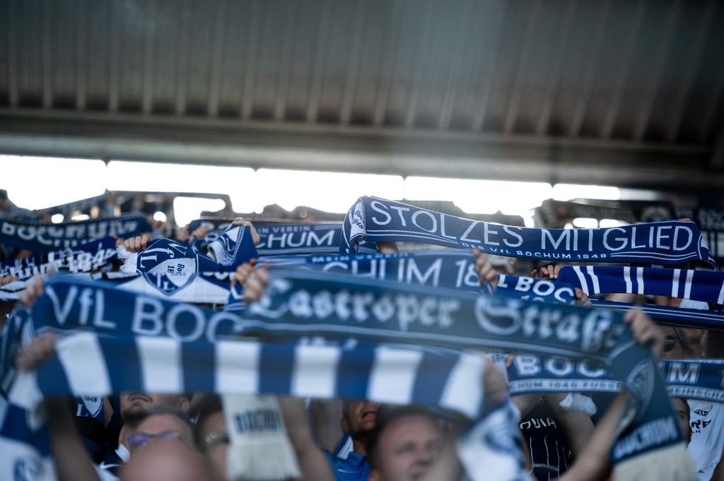 13.799 Zuschauer sind im Vonovia Ruhrstadion für das Spiel von Borussia Dortmund in Bochum zugelassen; VfL-Fans halten Schals hoch.