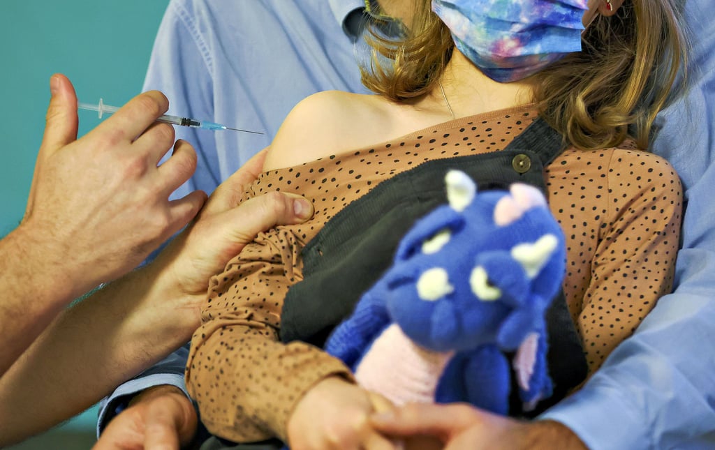 Ein Kinderarzt impft ein siebenjähriges Mädchen gegen das Coronavirus.
