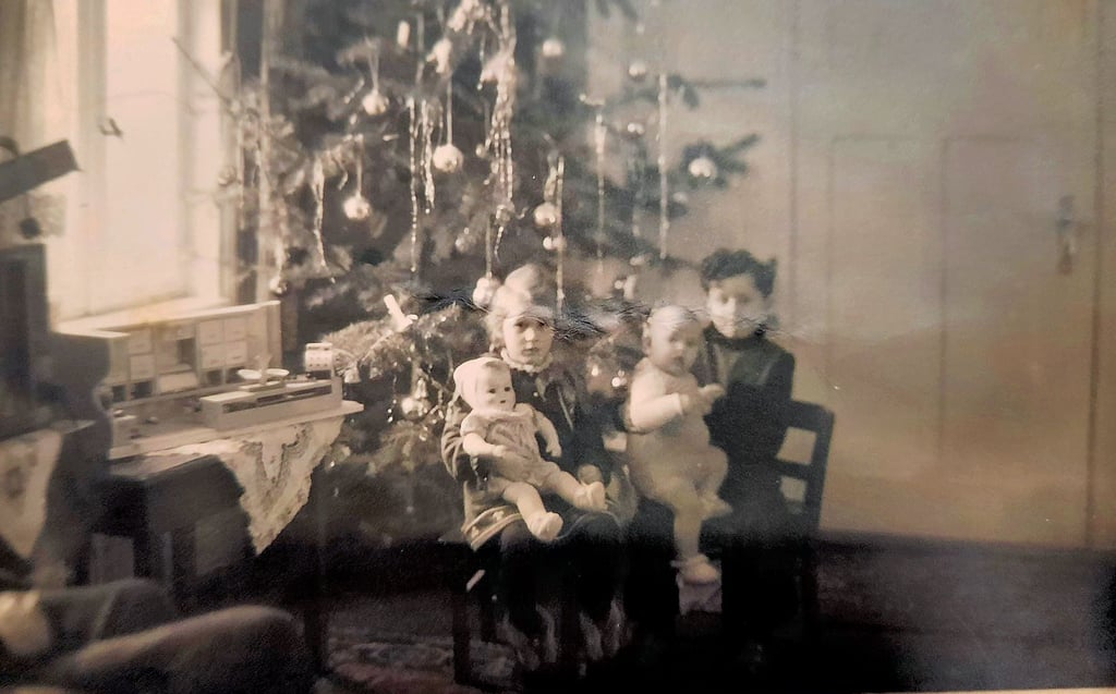 Dorothea Mollenhauer, als sie ein halbes Jahr alt war, sitzt auf dem Schoß ihres Bruders Eberhard, daneben Schwester Ilsabe. Links auf dem Gabentisch  ihr Weihnachtsgeschenk: ein Einkaufsladen.