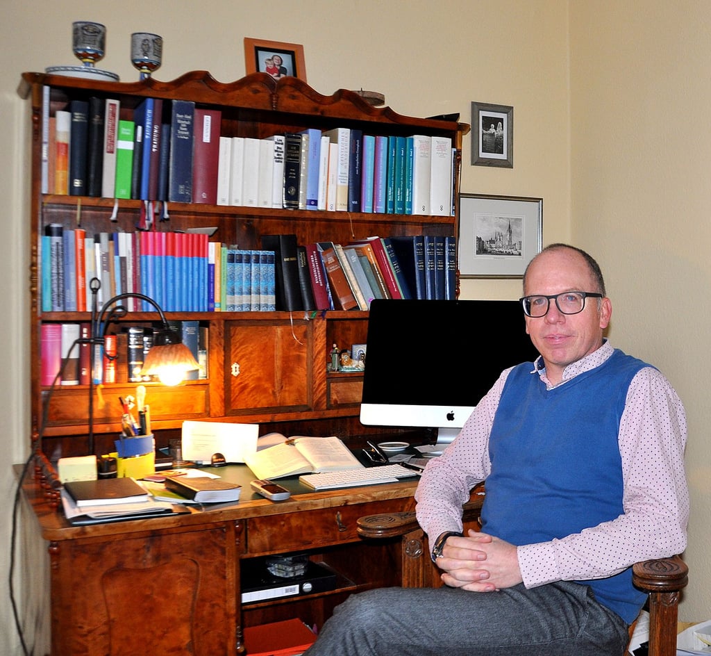 Teja Begrich an dem Schreibtisch von seinem Urgroßvater Karl-Gustav. Der 50-Jährige ist in achter Generation Pfarrer in der Familie Begrich.