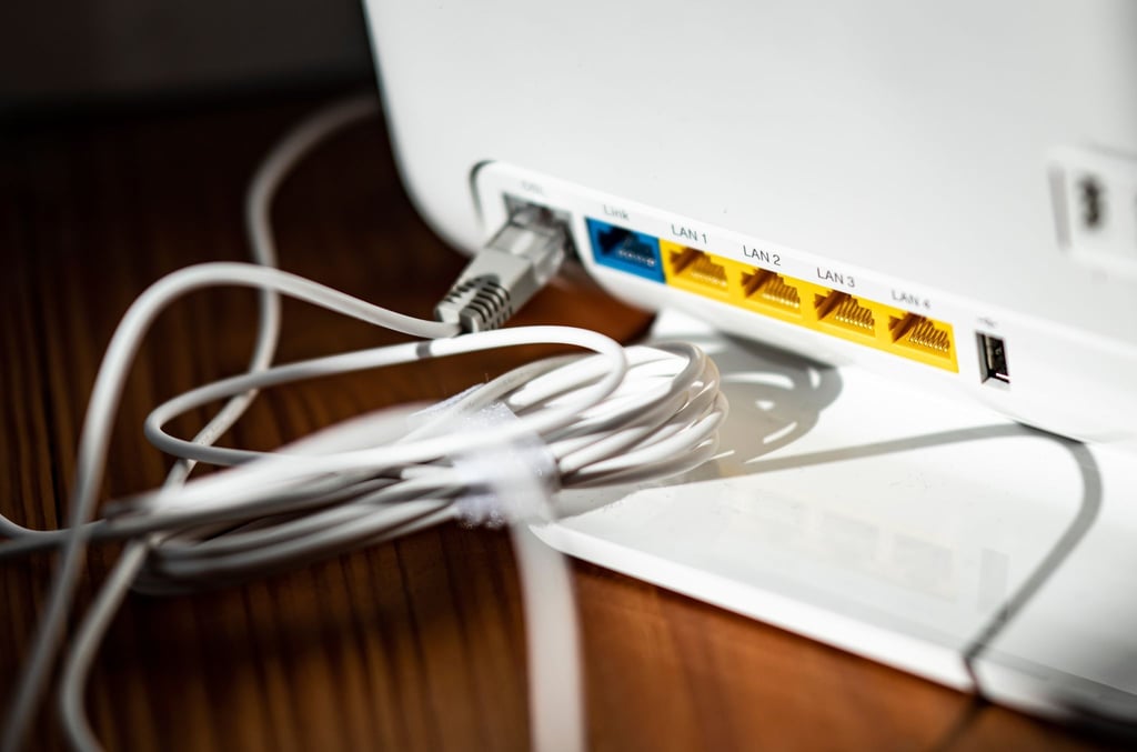 Ein LAN-Kabel steckt in einem WLAN-Router.