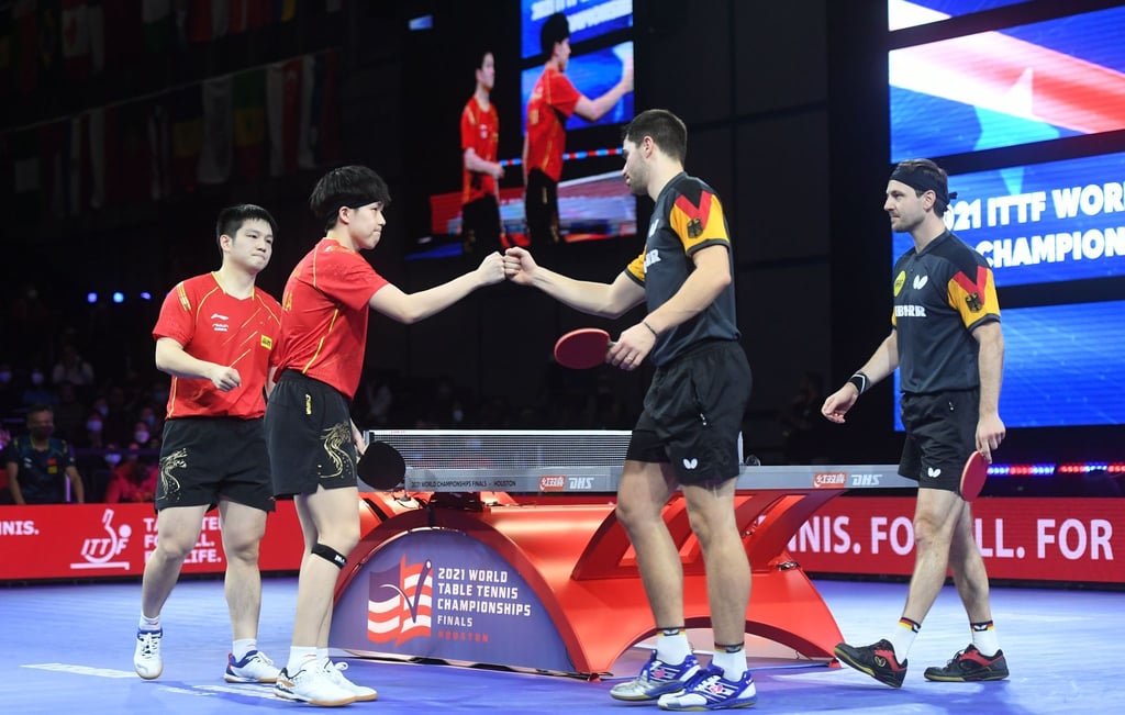 Wang Chuqin (2.v.l.) und Fan Zhendong (l) reagieren mit Patrick Franziska (2.v.r.) und Timo Boll nach dem Spiel.