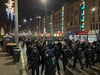 Polizisten laufen am Montagabend in der Altstadt von Magdeburg vor den Teilnehmern der Demonstration.
