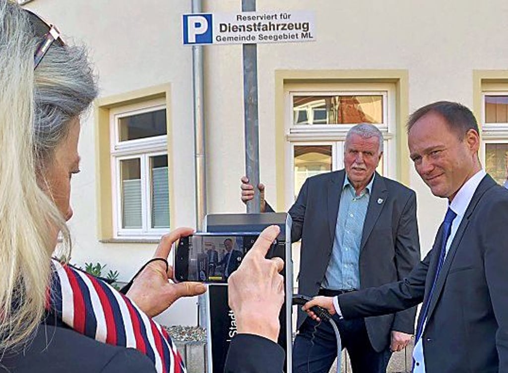 Stadtwerkechef Ronny Strebe (re.) und Bürgermeister Jürgen Ludwig nehmen die neue Ladesäule in Betrieb.