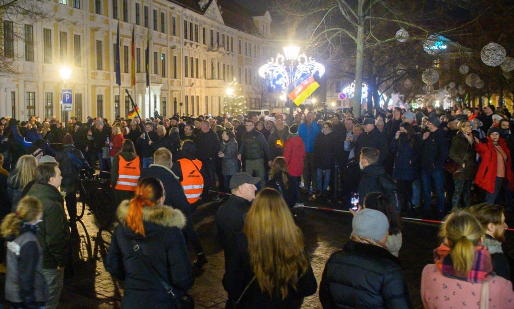 In Magdeburg stehen sich vor dem Landtag Gegner der Corona-Maßnahmen und Gegendemonstranten mit einem Absperrband gegenüber.