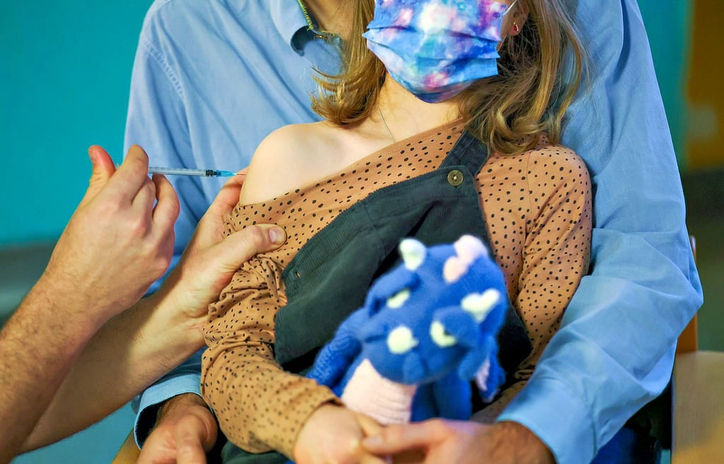 Ein Kinderarzt impft ein siebenjähriges Mädchen gegen das Sars-Cov-2-Virus. Foto: Woitas/dpa
