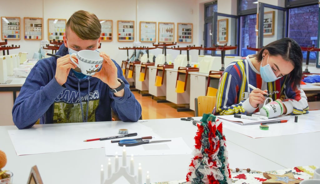 Die Schüler Max und Lisa gestalten am ersten Tag der Projektwoche ihre eigenen Tassen.