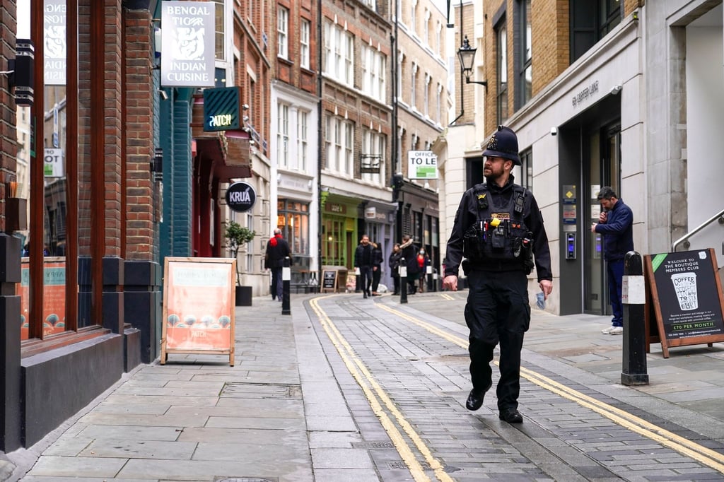 Ein Polizist läuft durch eine fast leere Straße im Londoner Finanzdistrikt.