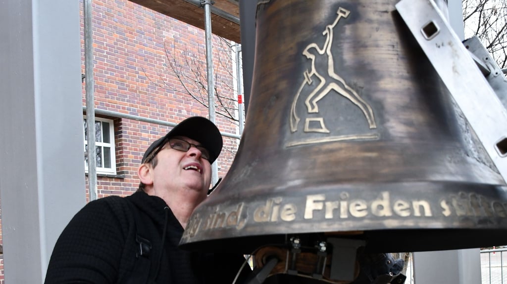 Wolfgang Schwarz befestigt den Klöppel an der neuen Friedensglocke der Matthäusgemeinde in Magdeburg-Stadtfeld.