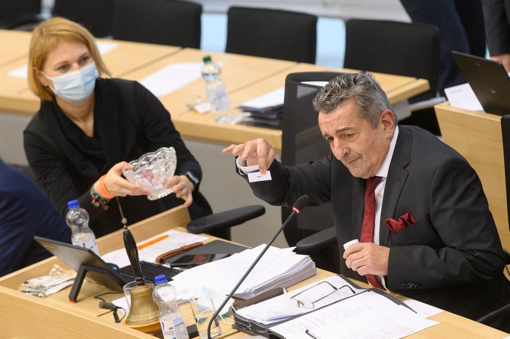 Gunnar Schellenberger (r), Präsident des Landtages von Sachsen-Anhalt zeigt einen kleinen Zettel auf dem "FDP" zu lesen ist.