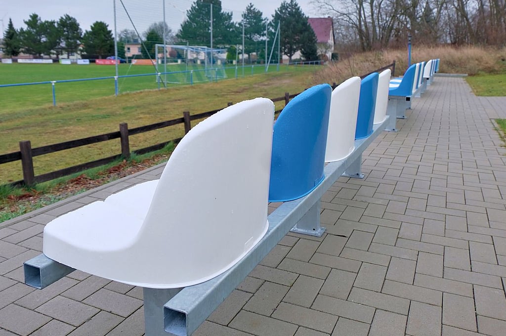 Die Sitzgelegenheiten sind in den Vereinsfarben des TSV gehalten. Der Untergrund ist mit Pflastersteinen versehen.