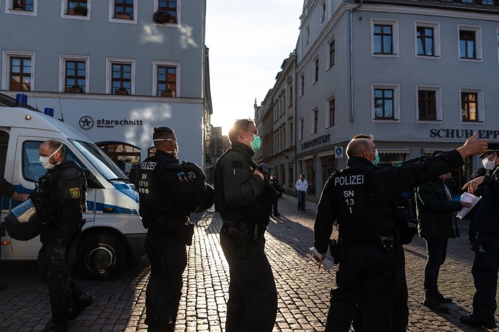 Polizisten stehen am Rand einer Demonstration von Gegnern der Corona-Maßnahmen auf dem Marktplatz in Pirna.