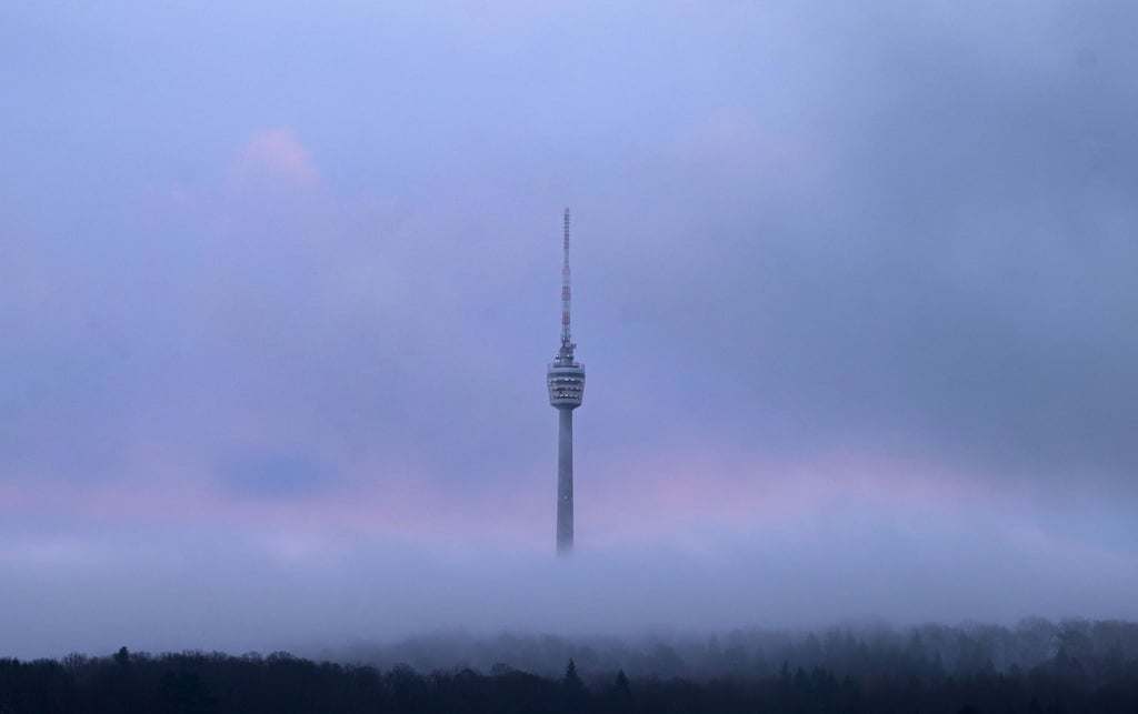Der Stuttgarter Fernsehturm am frühen Morgen zwischen Wolken.