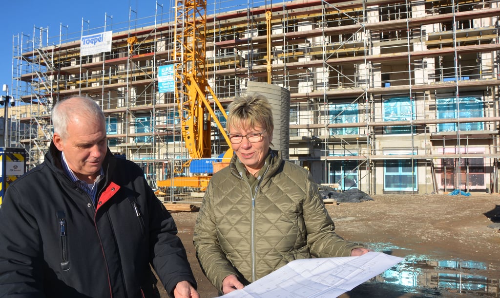 Die Vorstände der Burger Wohnungsbaugenossenschaft, Annette Janocha und Heino Näth, mit den Plänen für den neuen Komplex Martin-Luther-Straße/Gartenstraße. Im Hintergrund das erste Gebäude mit 15 Wohnungen.