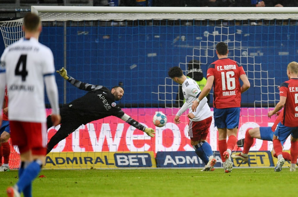 Hamburgs Ludovit Reis (M) erzielt den Treffer zum 2:0 gegen Rostocks Torhüter Markus Kolke (l).