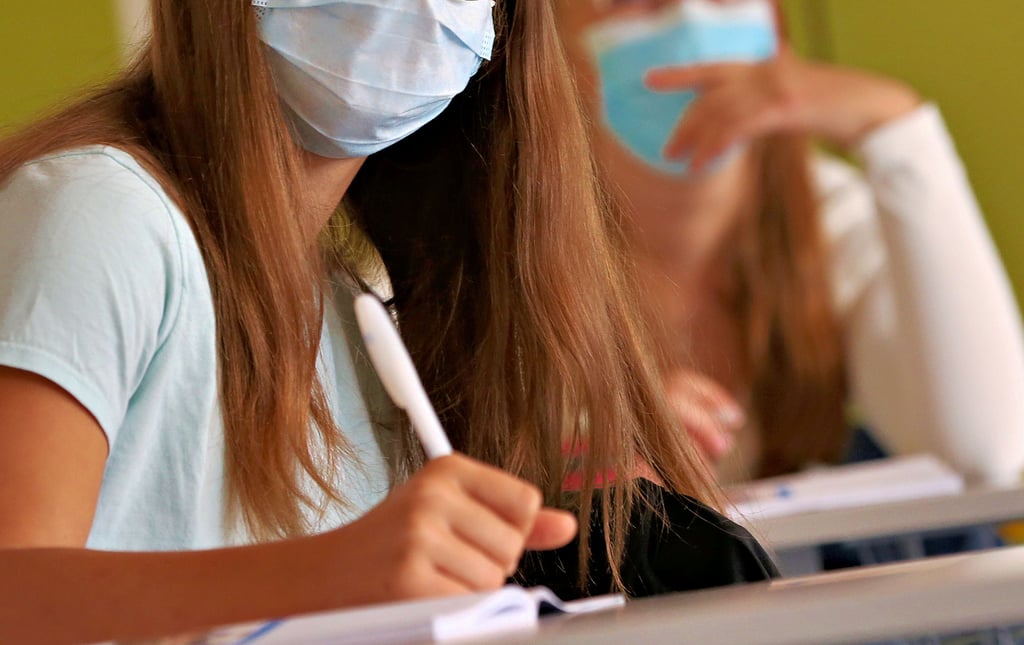 Schülerinnen mit Atemschutzmaske. Für medizinische Atteste zur Befreiung von der Maskenpflicht und von der Pflicht zu regelmäßigen Corona-Selbsttests verlangt das Landesschulamt Sachsen-Anhalt neuerdings eine Konkretisierung der „gesundheitlichen Gründe.“ Der Landesdatenschützer hält das für rechtswidrig.