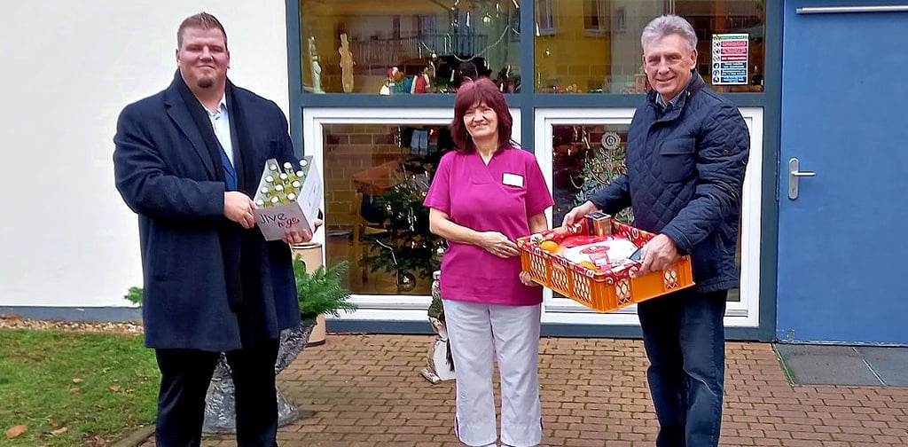 Vor der Pflegeeinrichtung übergeben Frank Nase und Manfred Behrens (v.l.) an Angelika Heinemann Weihnachtspräsente.