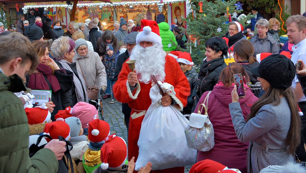 Vor zwei Jahren auf dem Stendaler Weihnachtsmarkt: Der Weihnachtsmann alias Hartmut Thomas war mit einem Feuerwehrauto vorgefahren und musste sich dann durch die Menge zur Bühne kämpfen. Seine Glocke hat er bei jedem Einsatz dabei.