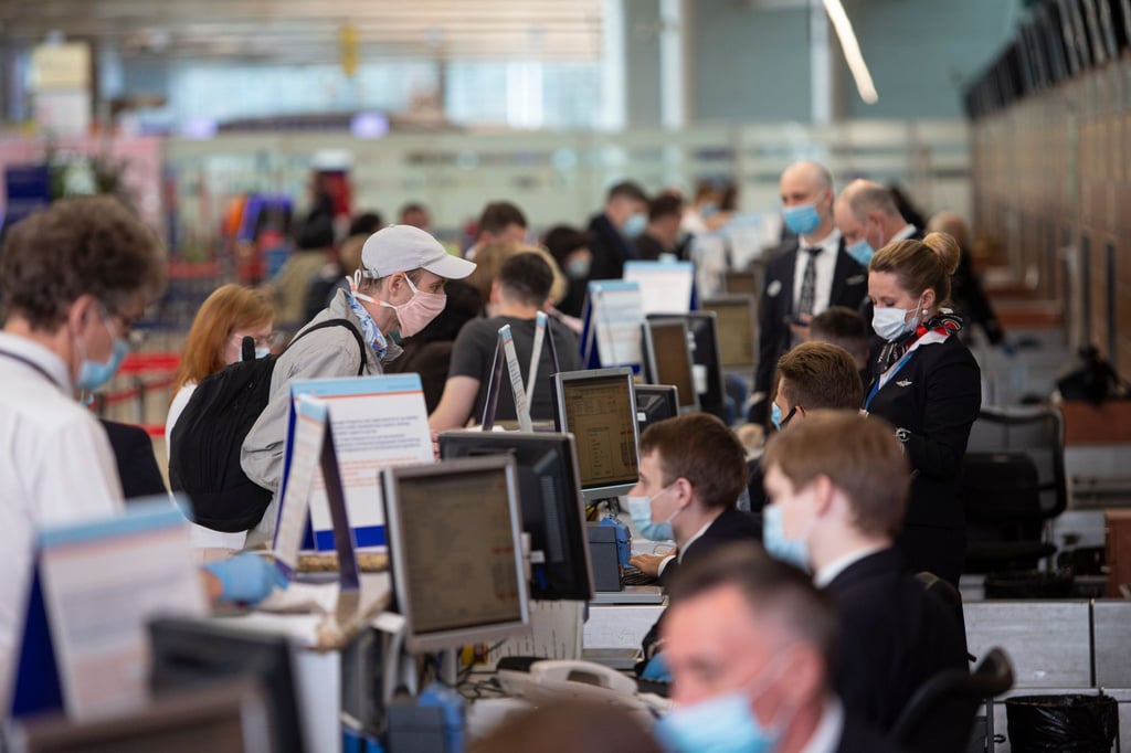 Passagiere vor Abfertigungsschaltern am Internationalen Flughafen Scheremetjewo in Moskau.