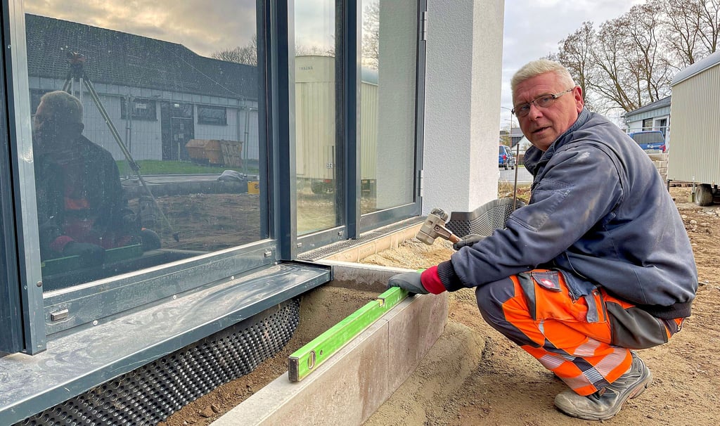 Frank Brauner vom Hecklinger Stadtbau-Betrieb beim Bordesetzen an der neuen Lebenshilfeverwaltung in Staßfurt.