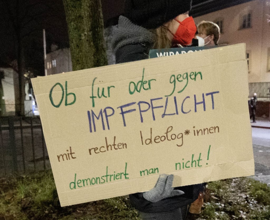 Eine Frau in Freiberg hält ein Schild in der Hand mit dem Text „Ob für oder gegen Impfpflicht mit rechten Ideolog*innen demonstriert man nicht!"