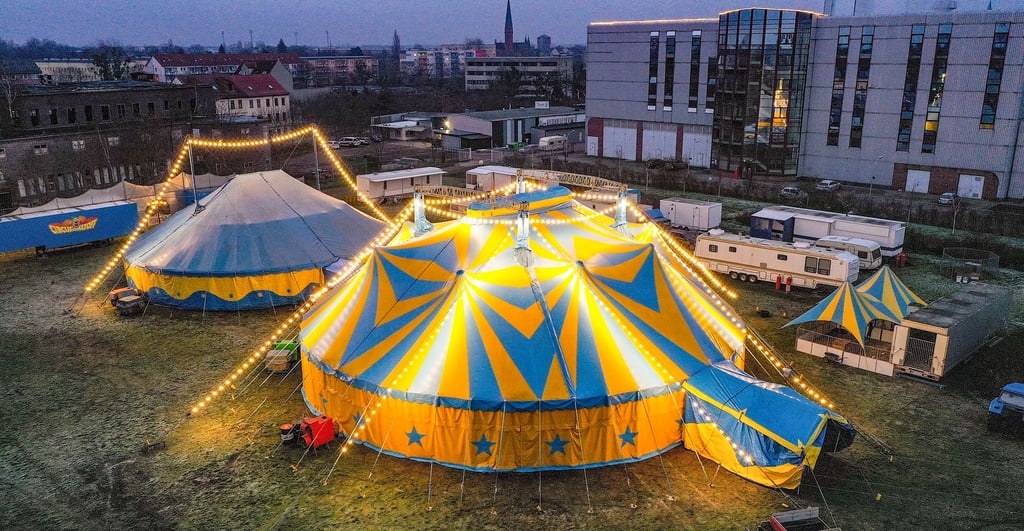 Das Zirkuszelt steht festlich beleuchtet vor dem Kraftwerk der Stadtwerke. Am 24. Dezember beginnt dort der Weihnachtscirkus.