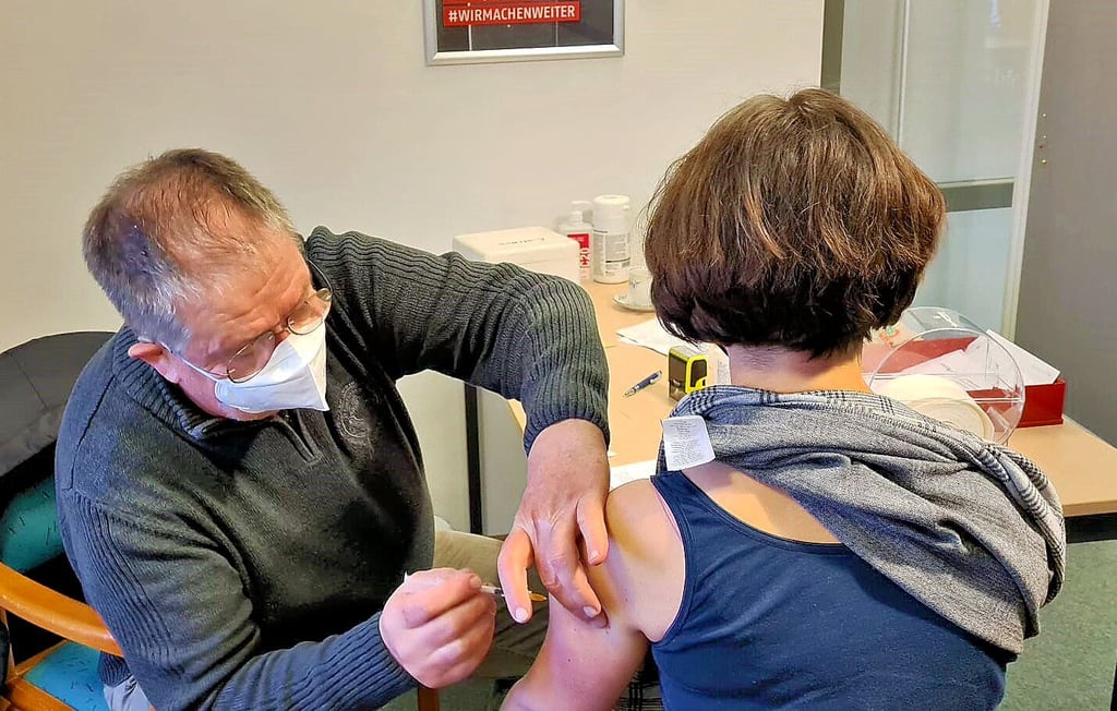 Der Vorstandschef des Awo-Kreisverbandes, Erhard Hellwig-Kühn, setzt die Spritze bei einer Mitarbeiterin.