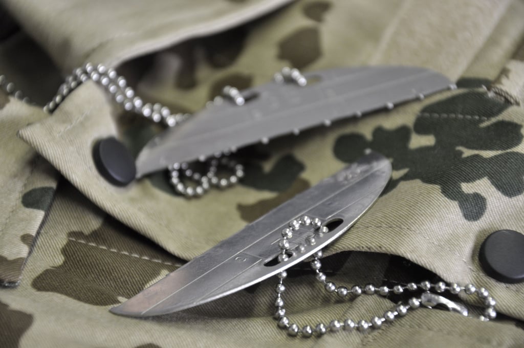 Auf einer Felddienstuniform liegt eine durchbrochene Erkennungsmarke der Bundeswehr. Die Blechmarke, die jeder Soldat im Dienst um den Hals trägt, enthält eine Codierung mit wichtigen persönlichen Daten wie unter anderem die Personenkennziffer und die Staatsangehörigkeit. Bereits im Zweiten Weltkrieg hatte jeder Soldat ein Erkennungsmarke zur Identifikation.
