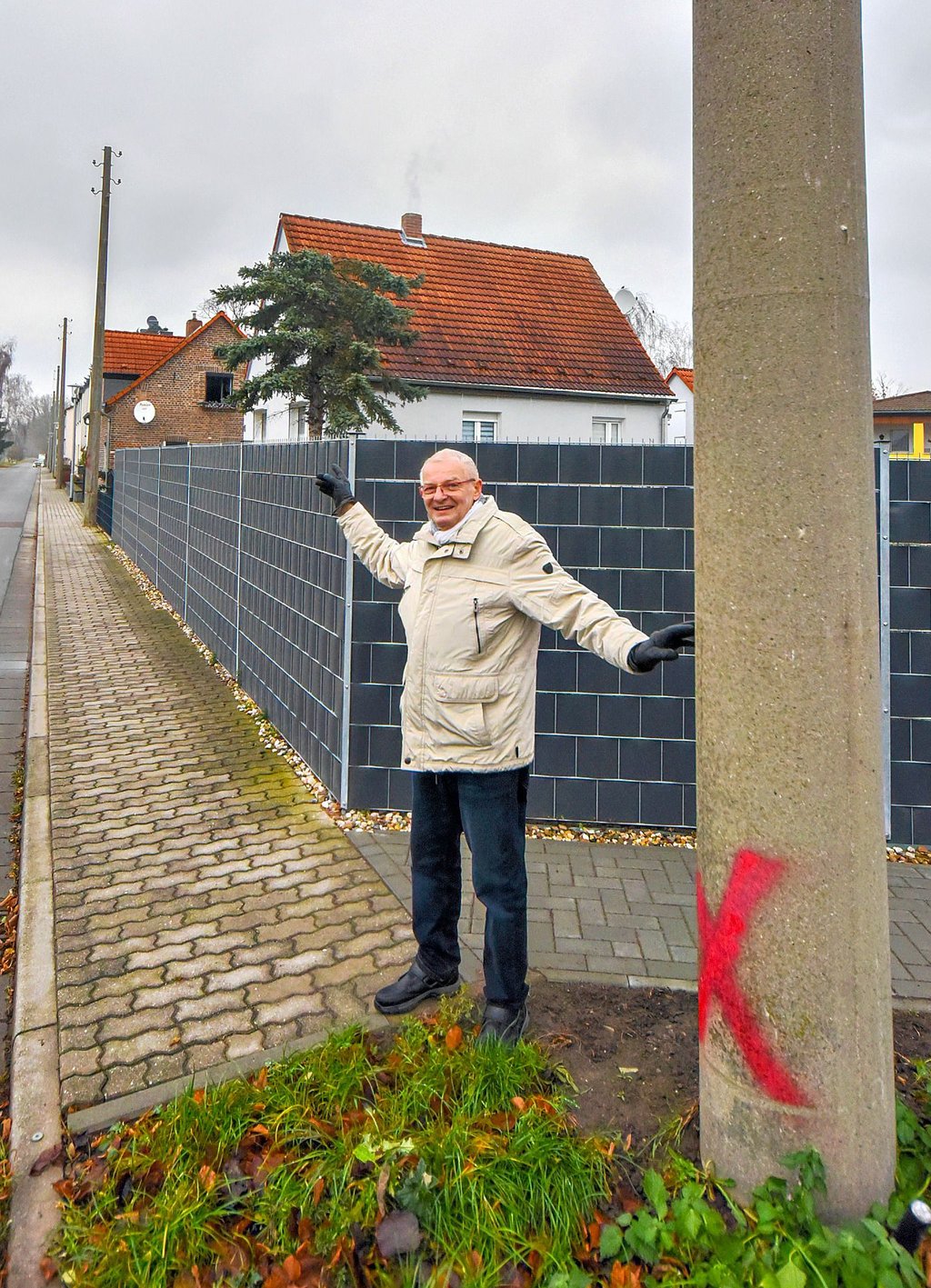 Axel Warmut zeigt, welche Betonmasten verschwinden sollen. Er möchte, dass mehrere davon stehenbleiben.