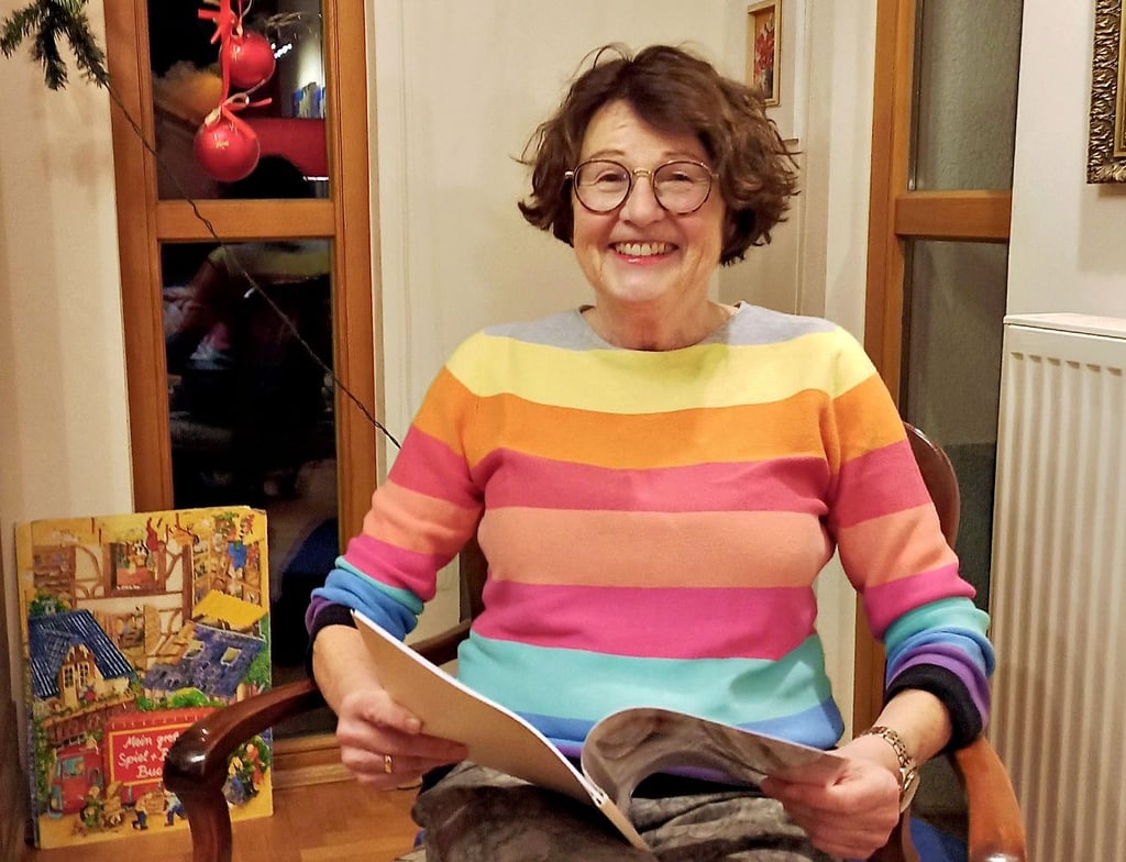 Eva Wybrands in ihrem Wohnzimmer in Biederitz mit dem Buch, das sie mit ihrer Enkelin Natalia geschrieben hat.