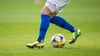 Ein Fußballspieler spielt den Ball.