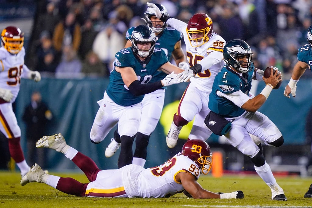 Eagles-Quarterback Jalen Hurts (r) läuft mit dem Football.