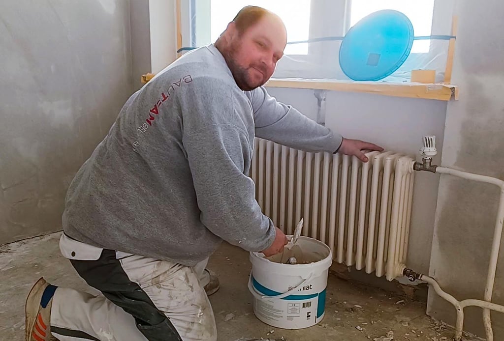 Sven Thomas vom Bauteam Belleben erledigt mit dem Spachtel Feinarbeiten in einem Klassenraum der Grundschule.
