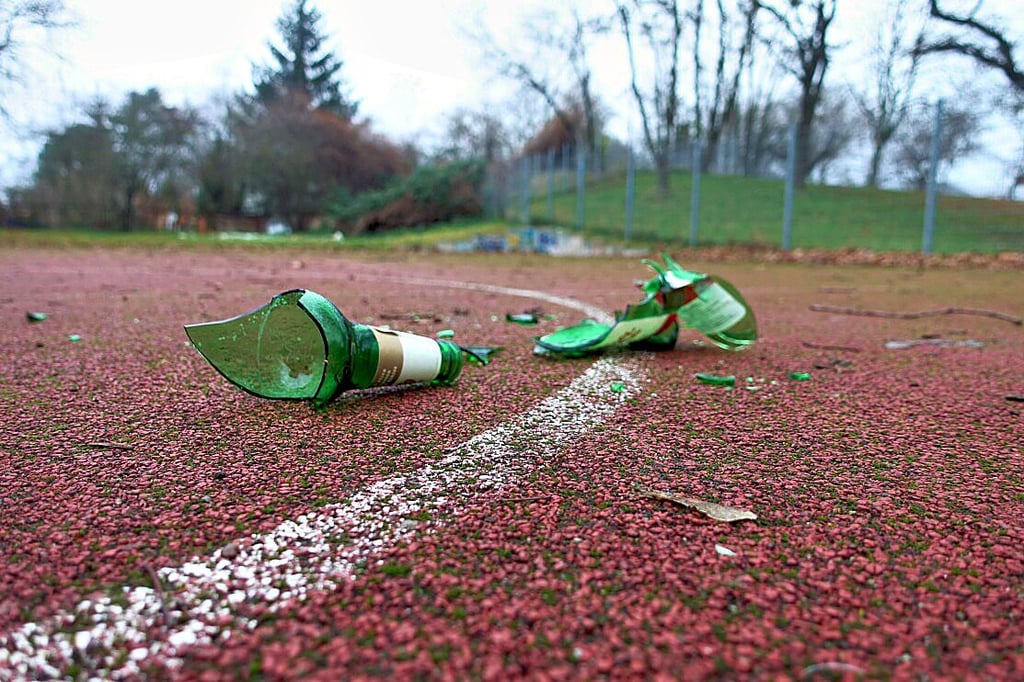 Eine zerbrochene Bierglasflasche mitten auf der ausgedienten Tartan-Sportfläche am Klusdamm in Magdeburg.
