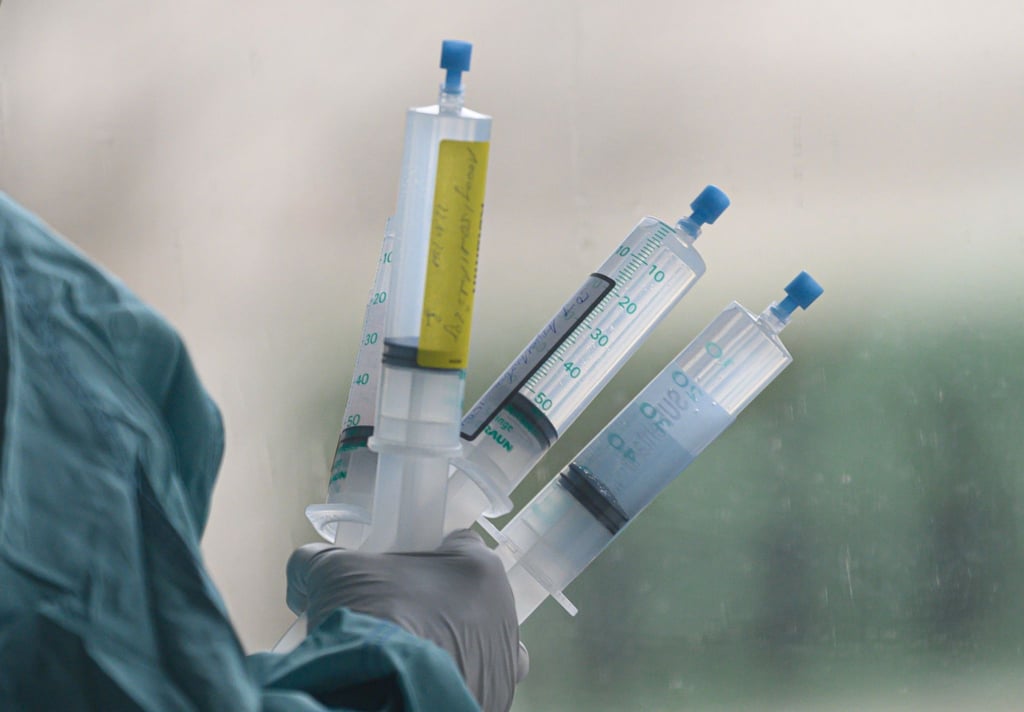 Ein Intensivpflegerin hält Medikamente für eine Corona-Patientin in der Hand.