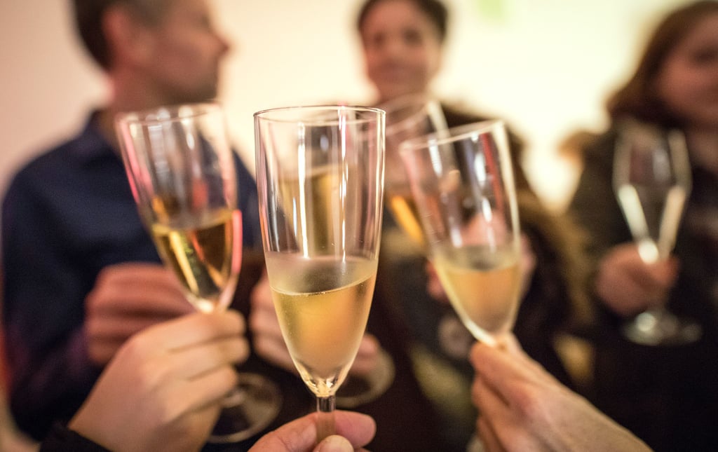 Gäste einer Silvesterparty stoßen an. Die Flaschenkorken dürfen auch in diesem Jahr knallen. Gefeiert werden darf aber nur im kleinen Kreis und ohne Feuerwerk.