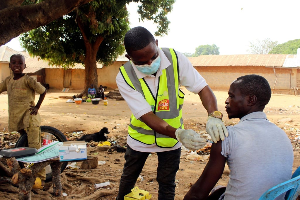 Ein kommunaler Gesundheitshelfer verabreicht einem Mann in Nigeria den Corona-Impfstoff.
