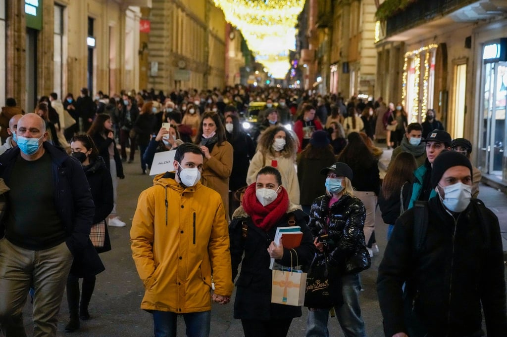 Menschen gehen durch eine Einkaufsstraße in Rom. In Italien sind die Corona-Zahlen erneut in die Höhe geschossen.