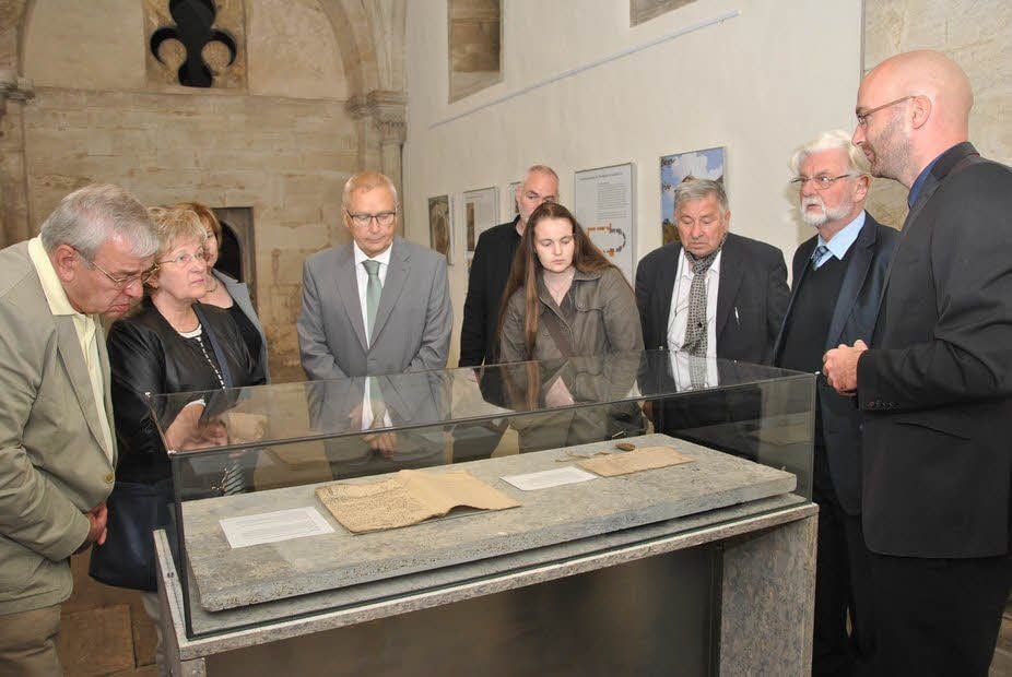 Matthias Ludwig (r.) erläutert eine Urkunde mit dem Siegel des Bischofs Ulrich.
