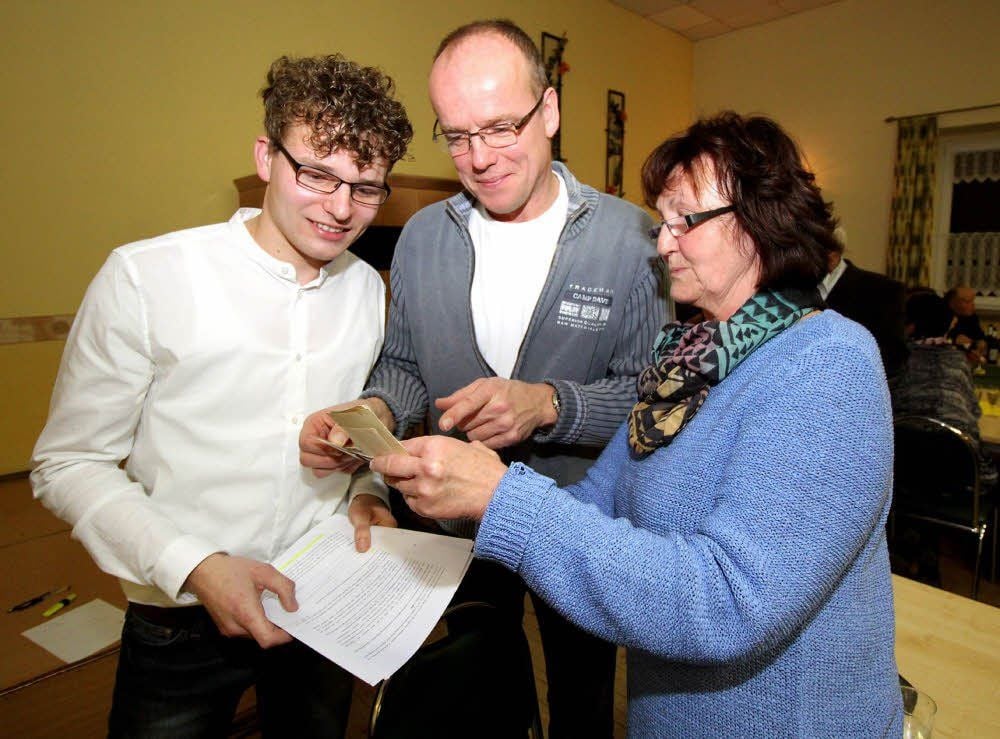 Brachte Fotos aus dem Dorfleben mit: Marlies Lützkendorf. Ortschronist Paul Jänicke (links) und Fred Jänicke freuen sich über den Zuwachs für die Chronik.