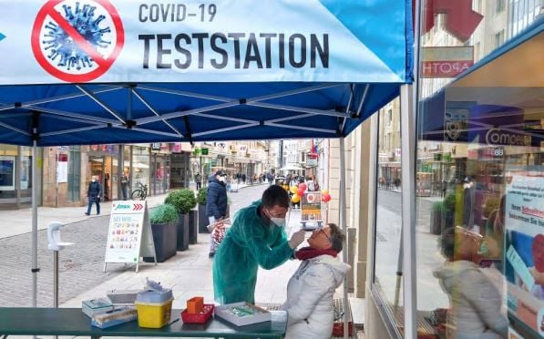 Vor der Halloren-Apotheke können sich Hallenser auf Corona testen lassen, während in den Geschäften auf dem Boulevard noch geshoppt werden kann.