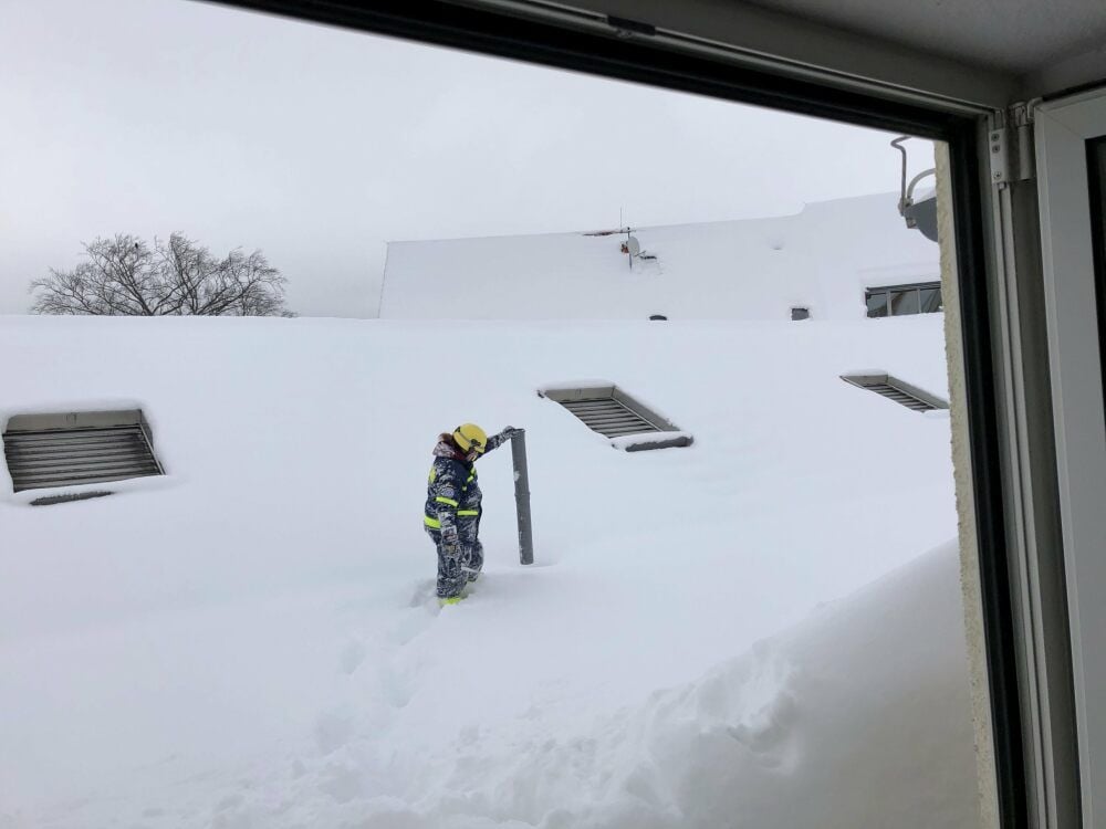 Schneelastmessung in Blankenburg: Jeanine Odenbach vom THW Quedlinburg steckt auf dem Flachdach des Gebäudes ein Rohr in den Schnee.