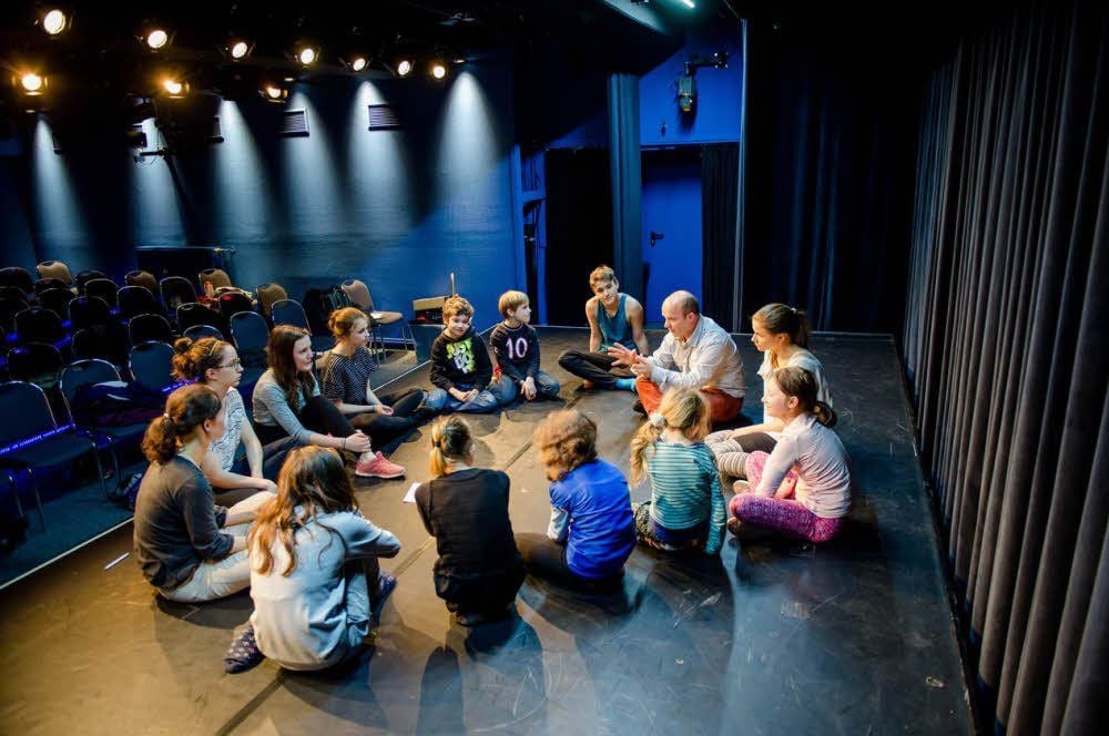Brainstorming auf der Theaterbühne: Schauspieler und Workshopleiter Hans-Georg Pachmann bespricht mit den Kindern und Jugendlichen Ideen. Er wird unterstützt von seiner Tochter Sarah.