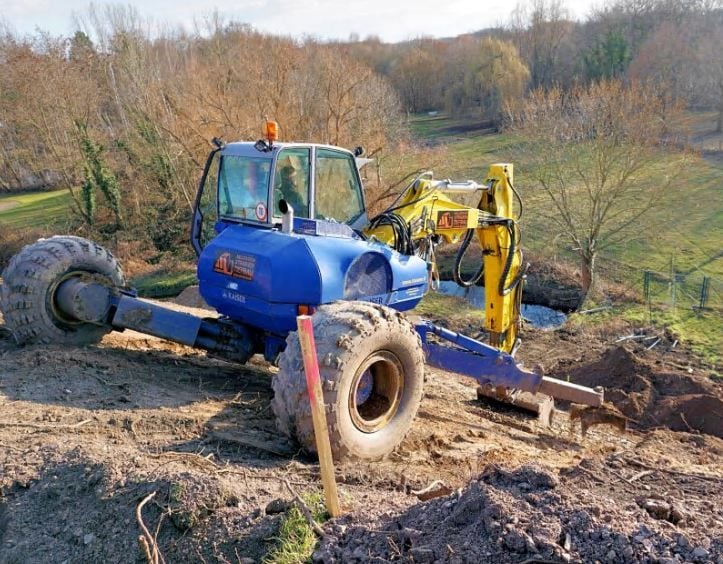 Mit der Schaufel nach vorn, geht es den Hang hinunter. Der Boden wird dort abgetragen.