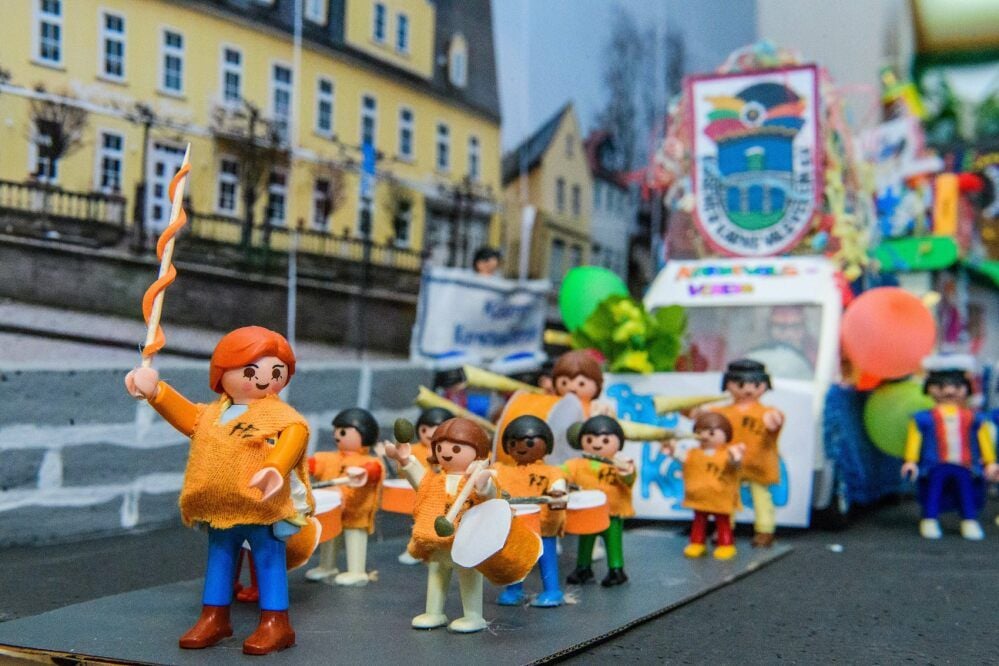 Mit Playmobil-Figuren und -Fahrzeugen wird vor der Kulisse von Café Schoppe und Mutigem Ritter ein Umzug nachgestellt.