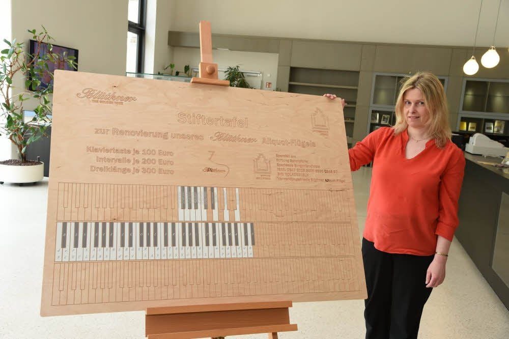 Pianistin Silvia Heyder mit der Spendertafel, die im Besucherzentrum in Schulpforte steht.