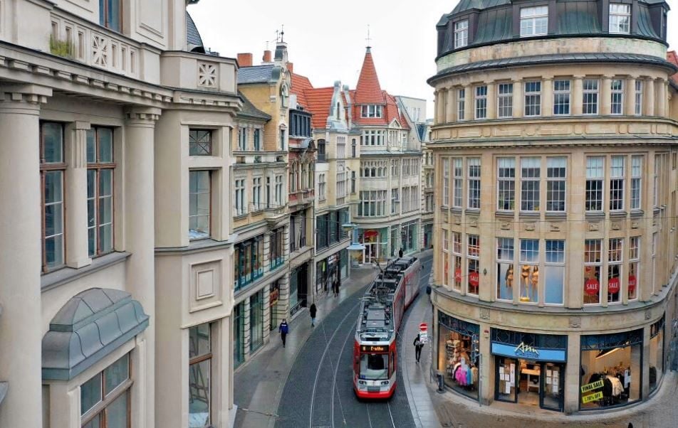 Eine Straßenbahn fährt durch die enge Häuserschlucht in der Großen Ulrichstraße. Ab 2024 sollen die neuen Züge durch Halle rollen.