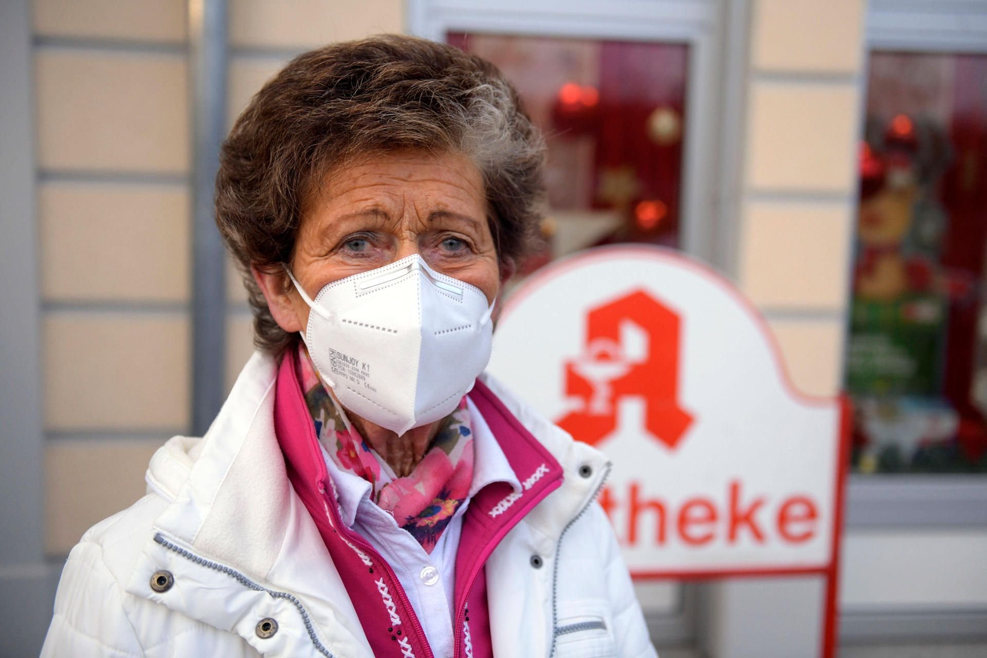 Eine Frau steht mit einer FFP2-Maske vor einer Apotheke. (Symbolbild)