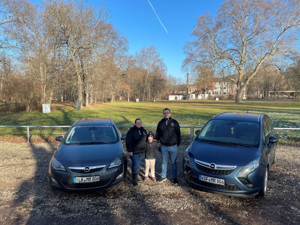 Rebecca und Maik Prinz stehen mit ihrer Tochter Lena zwischen ihren beiden geliebten Opelfahrzeugen.